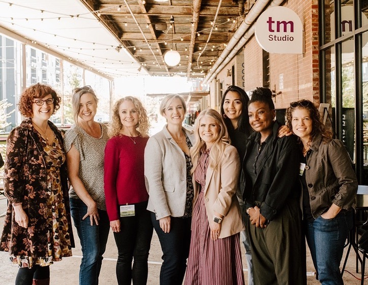 Seven women from the Charlotte B Corp Collective gathered at a community event.